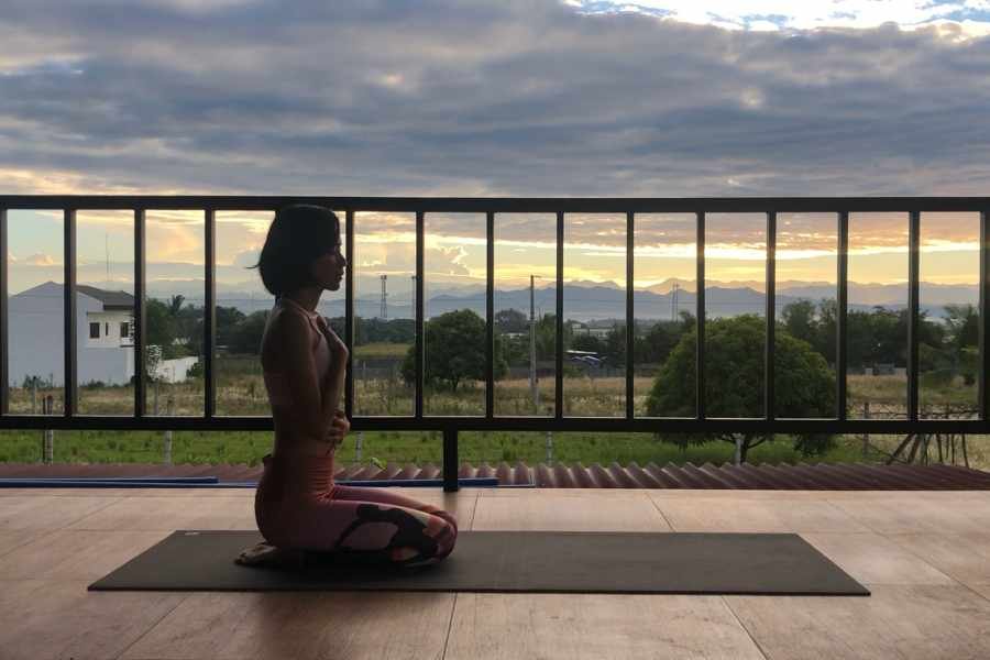 An image of Jenny meditating on her yoga mat at sunrise. Photo taken by Jenny Blancaflor